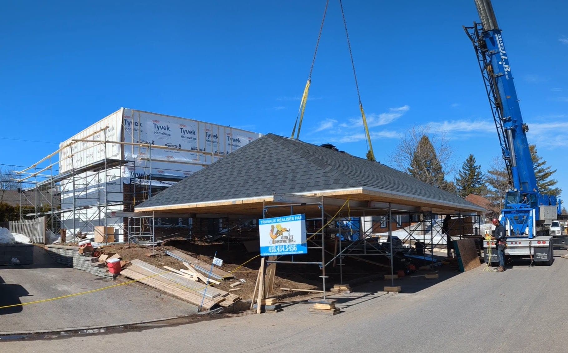 Construction d'une toiture au sol, prête à être levée avec la grue